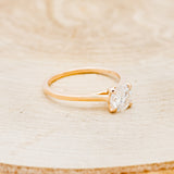 Shown here is a solitaire-style moissanite women's engagement ring with 4 claw prongs, facing right. Many other center stone options are available upon request.