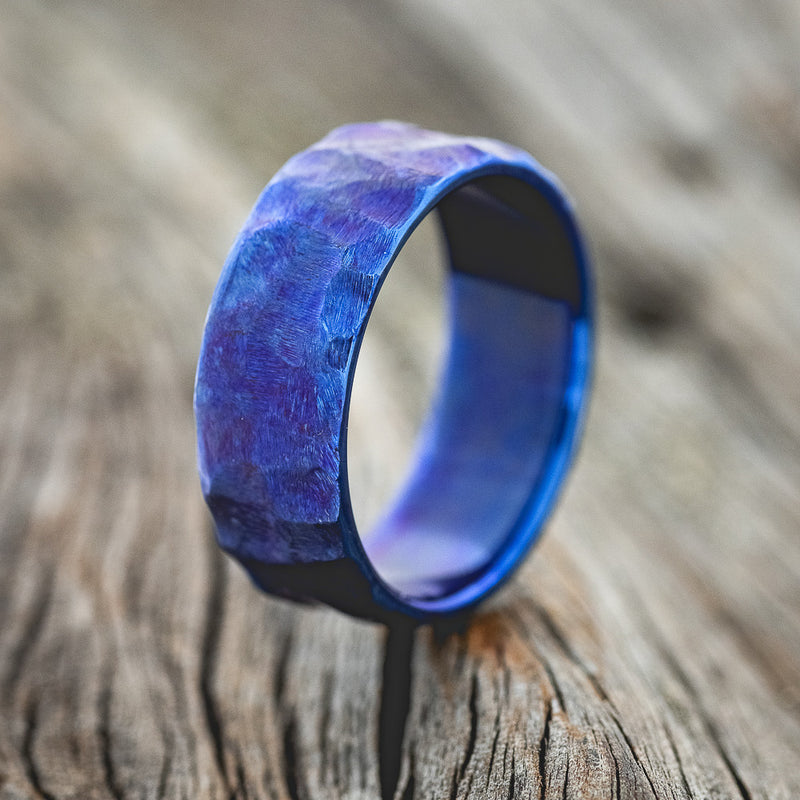 Shown here is a handcrafted men's wedding ring featuring a fire-treated and seascaped titanium band, upright facing left