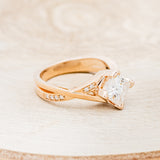 Shown here is "Lina", a moissanite women's engagement ring with diamond accents, facing right. Many other center stone options are available upon request.