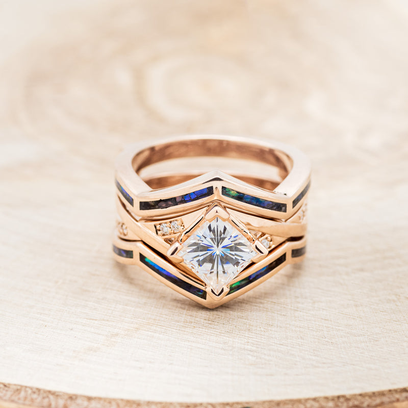 Shown here is "Lina", a moissanite women's engagement ring with diamond accents and a paua shell ring guard, front facing. Many other center stone options are available upon request.