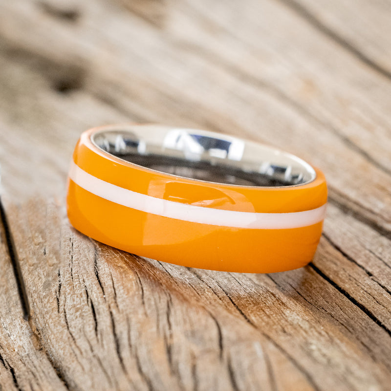 Shown here is "Remmy", a custom, handcrafted men's wedding ring featuring a hand-turned orange & white acrylic, tilted left. Additional inlay options are available upon request.