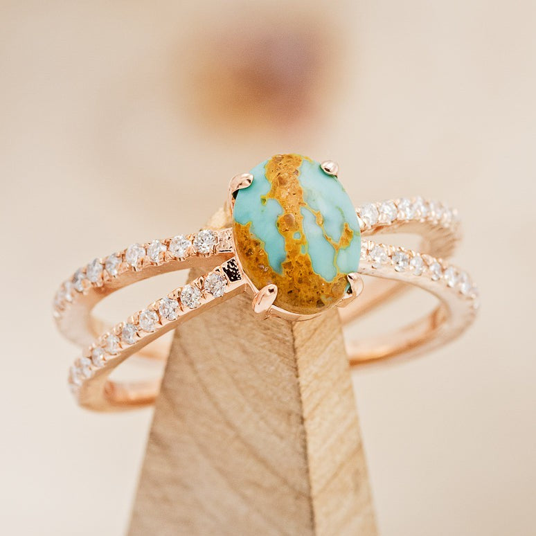 Shown here is "Anastasia", a split shank-style turquoise women's engagement ring with diamond accents, on stand front facing. 