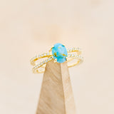 Shown here is "Anastasia", a split shank-style turquoise women's engagement ring with diamond accents, on stand front facing.