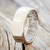 Shown here is a custom, handcrafted men's wedding ring featuring a unique antler lining, upright facing left. Additional inlay options are available upon request.