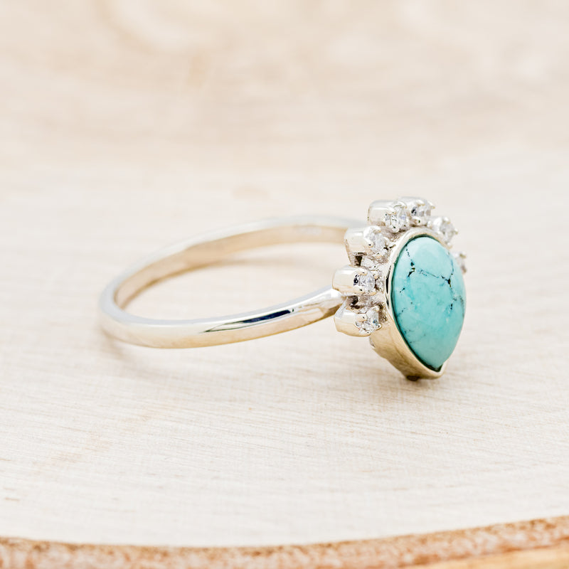 Shown here is "Shania", a turquoise women's engagement ring with diamond accents, facing right. Many other center stone options are available upon request.
