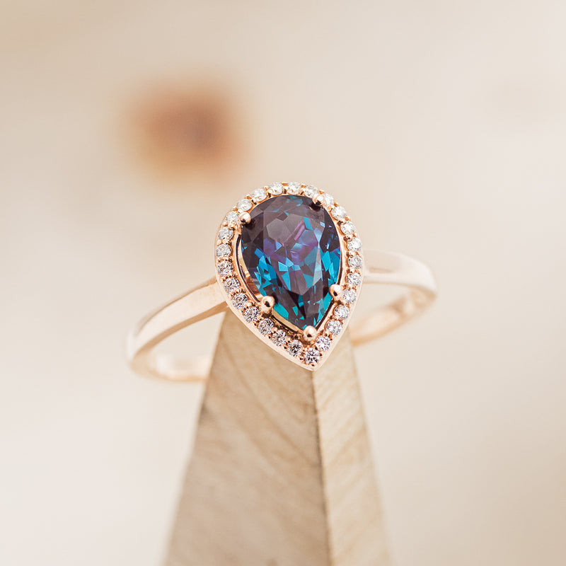 Shown here is The "Clariss", a halo-style pear alexandrite women's engagement ring with delicate and ornate details and is available with many center stone options.Chatham Alexandrite Engagement Ring With Diamond Halo - Staghead Designs