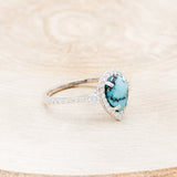 Shown here is "KB", a turquoise women's engagement ring with a diamond halo and diamond accents, facing right. Many other center stone options are available upon request.