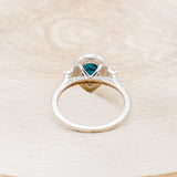 Shown here is "KB", a turquoise women's engagement ring with a diamond halo and diamond accents, back view. Many other center stone options are available upon request.