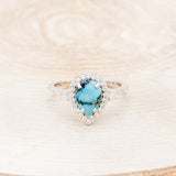 Shown here is "KB", a turquoise women's engagement ring with a diamond halo and diamond accents, front facing. Many other center stone options are available upon request.