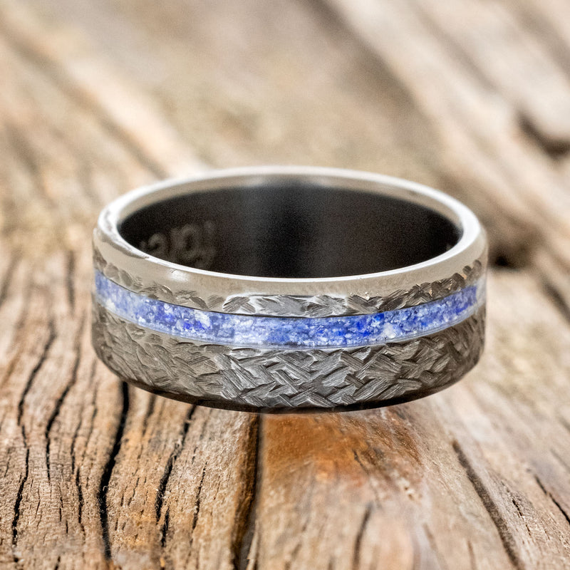 Shown here is "Vertigo", a custom, handcrafted men's wedding ring featuring a lapis lazuli inlay with a crosshatched finish, laying flat. Additional inlay options are available upon request.