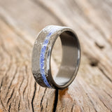 Shown here is "Vertigo", a custom, handcrafted men's wedding ring featuring a lapis lazuli inlay with a crosshatched finish, upright facing left. Additional inlay options are available upon request.