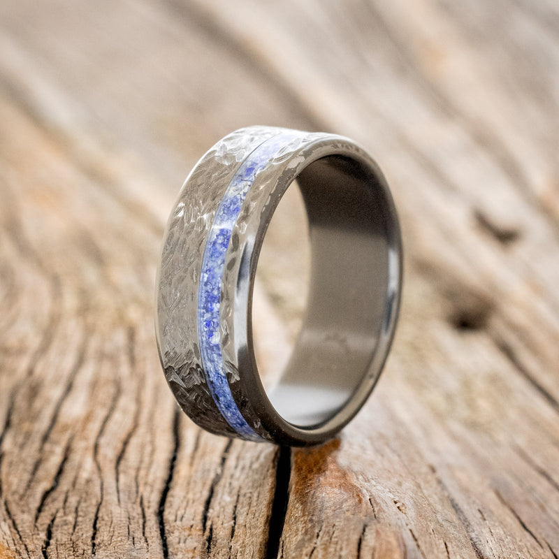 Shown here is "Vertigo", a handcrafted men's wedding ring featuring a lapis lazuli inlay with a crosshatched finish, upright facing left.
