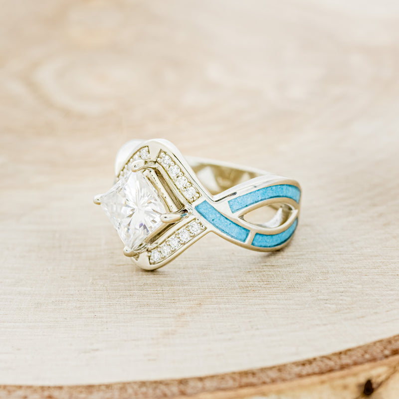 Shown here is "Helix", a geometric-style princess cut moissanite women's engagement ring with diamond accents and turquoise inlays, facing left. Many other center stone options are available upon request.