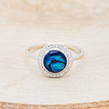 Shown here is "Terra", a round paua shell women's engagement ring with a diamond halo, front facing. Many other center stone options are available upon request.