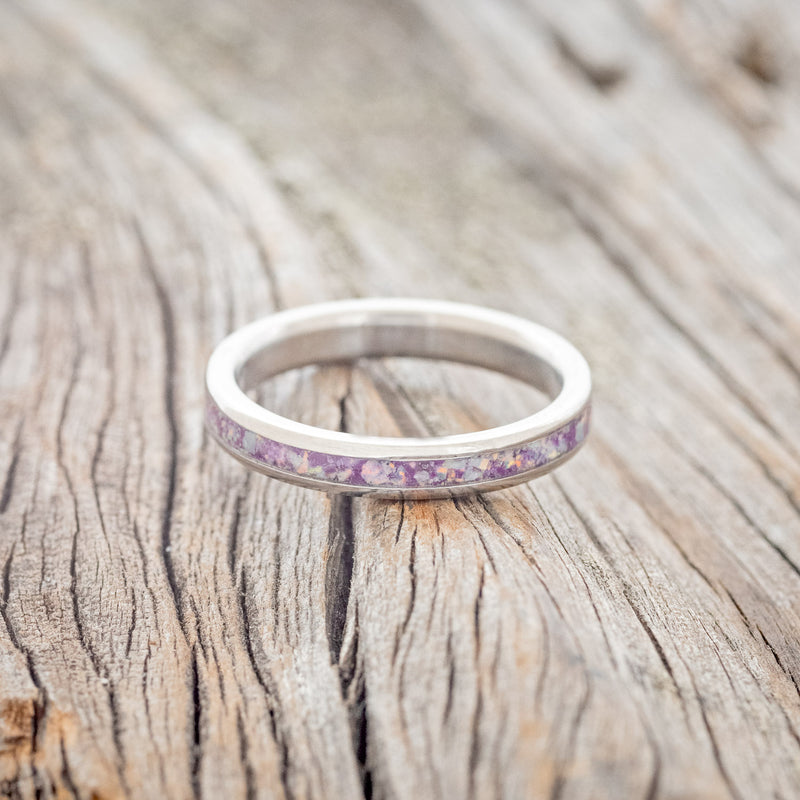 Shown here is "Eterna", a custom, handcrafted women's stacking band featuring a sugilite inlay mixed with fire & ice opal, shown here on a titanium band, laying flat. Additional inlay options are available upon request.