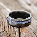 Shown here is "Vertigo", a handcrafted men's wedding ring shown featuring an offset mix of lapis lazuli and fire & ice opal inlay, laying flat.