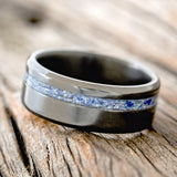 Shown here is "Vertigo", a custom, handcrafted men's wedding ring featuring a beautiful mixture of lapis lazuli & fire and ice inlay, shown here on a fire-treated black zirconium band, tilted left. Additional inlay options are available upon request.