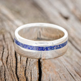 Shown here is "Vertigo", a custom, handcrafted men's wedding ring featuring a beautiful mixture of lapis lazuli & fire and ice opal inlay, laying flat. Additional inlay options are available upon request.