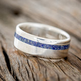 Shown here is "Vertigo", a custom, handcrafted men's wedding ring featuring a beautiful mixture of lapis lazuli & fire and ice inlay, tilted left. Additional inlay options are available upon request.