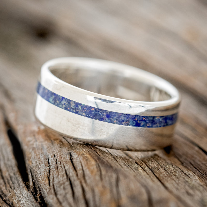 Shown here is "Vertigo", a custom, handcrafted men's wedding ring featuring a beautiful mixture of lapis lazuli & fire and ice opal inlay, tilted left. Additional inlay options are available upon request.