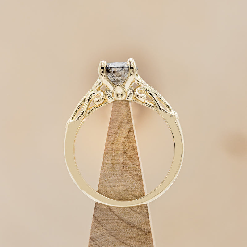 Shown here is "Rosemary", a vintage-style women's engagement ring with sculptural-inspired band displayed here with a round salt and pepper diamond but listed here as a mounting-only option, side view on stand. Follow the instructions above to select your stone.