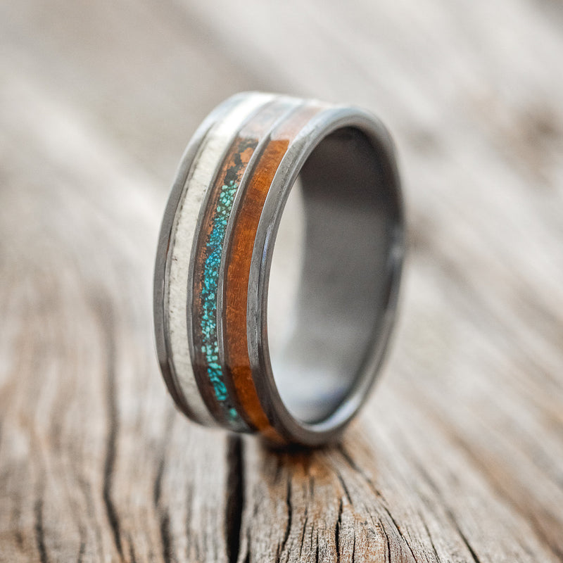 Shown here is "Rio", a custom, handcrafted men's wedding ring featuring 3 channels with elk antler, patina copper, and ironwood, upright facing left. Additional inlay options are available upon request.