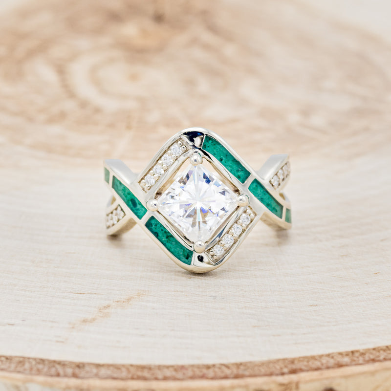 Shown here is "Helix", a geometric-style princess cut moissanite women's engagement ring with diamond accents and malachite inlays, front facing. Many other center stone options are available upon request.