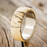 Shown here is "Haven", a custom, handcrafted men's wedding ring featuring a spalted maple wood overlay, upright facing left. Additional overlay options are available upon request.