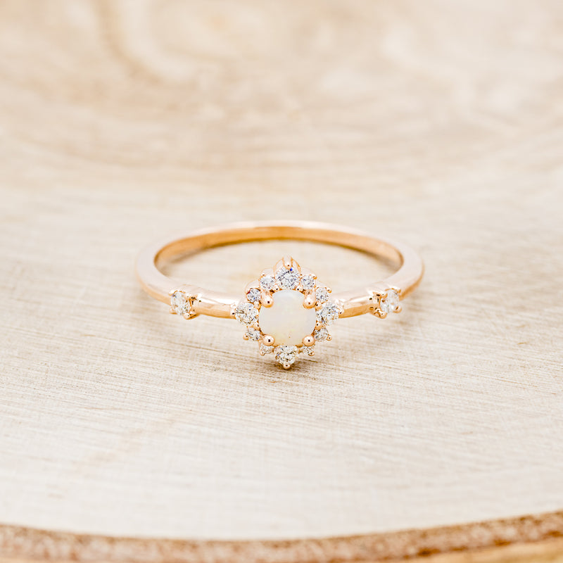 Shown here is "Starla", a round cut opal women's engagement ring with a starburst diamond halo, front facing. Many other center stone options are available upon request.