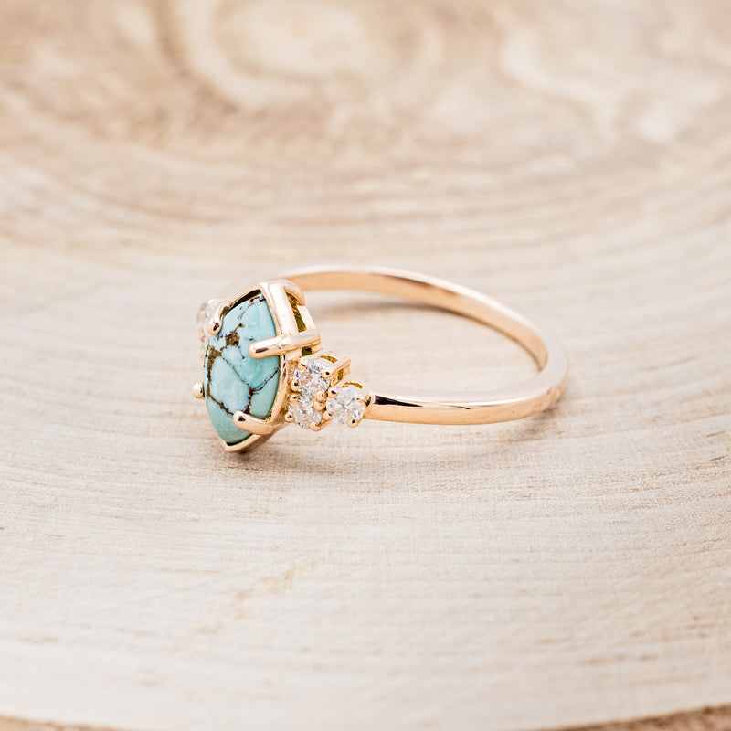 Shown here is "Raya", a turquoise women's engagement ring with diamond accents, facing left. Many other center stone options are available upon request.