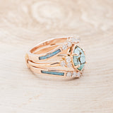 Shown here is "Raya", a turquoise women's engagement ring with diamond accents and a ring guard, facing right. Many other center stone options are available upon request.