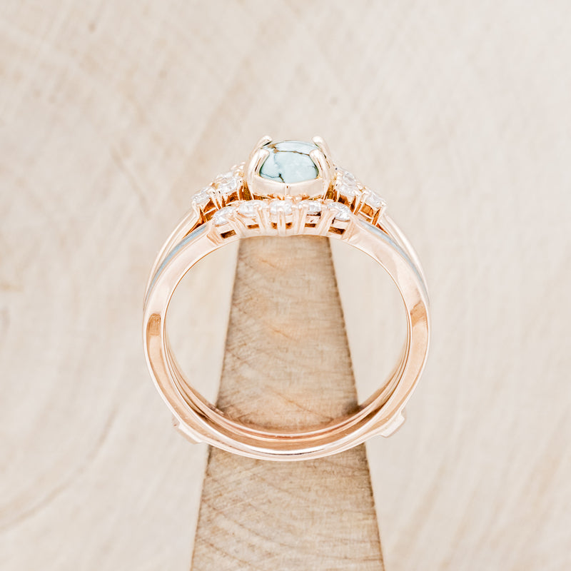 Shown here is "Raya", a turquoise women's engagement ring with diamond accents and a ring guard, side view on stand. Many other center stone options are available upon request.