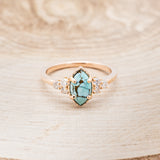 Shown here is "Raya", a turquoise women's engagement ring with diamond accents, front facing. Many other center stone options are available upon request.