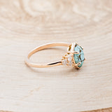Shown here is "Raya", a turquoise women's engagement ring with diamond accents, facing right. Many other center stone options are available upon request.