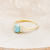 Shown here is "Rhea", a turquoise women's engagement ring with diamond accents, facing left. Many other center stone options are available upon request.