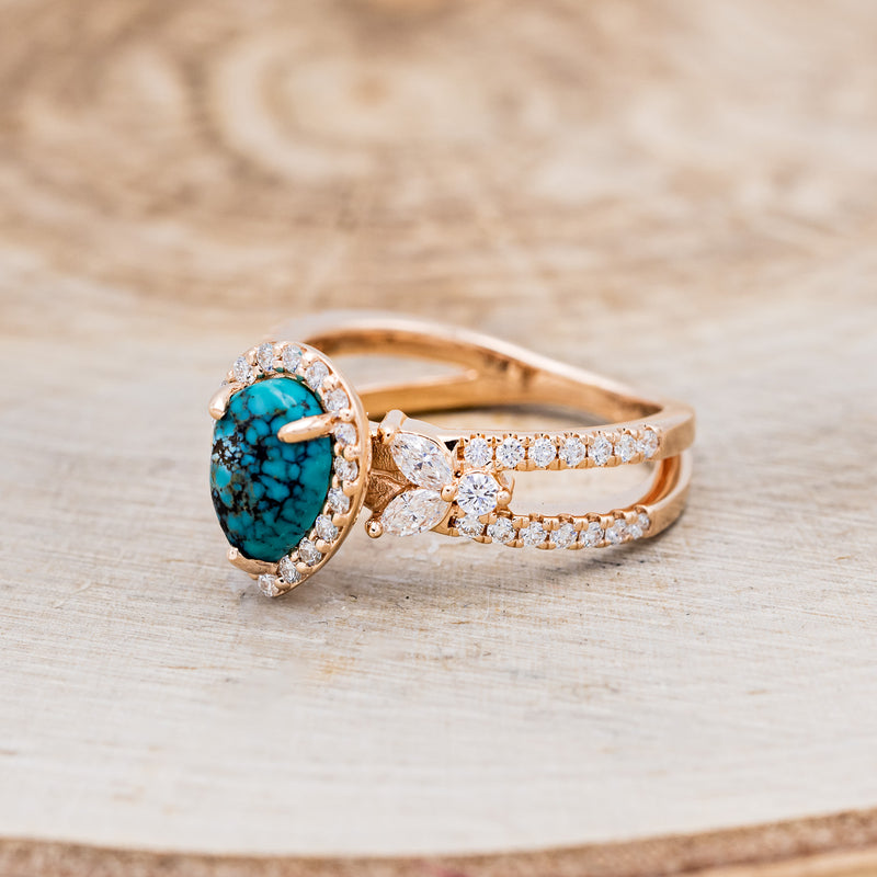 Shown here is "Loretta", a split shank-style turquoise women's engagement ring with a diamond halo and leaf-shape diamond accents, facing left. Many other center stone options are available upon request.