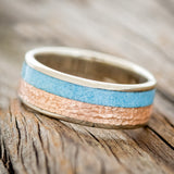 Shown here is a custom, handcrafted men's wedding ring featuring turquoise and hammered 14K rose gold inlay, tilted left. Additional inlay options are available upon request.