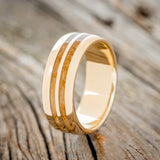 Shown here is "Silas", a handcrafted men's wedding ring featuring two whiskey barrel wood inlays on a domed profile band, upright facing left. Additional inlay options are available upon request.
