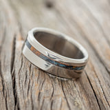 Shown here is "Vertigo", a custom, handcrafted men's wedding ring featuring a patina copper inlay, tilted left. Additional inlay options are available upon request.