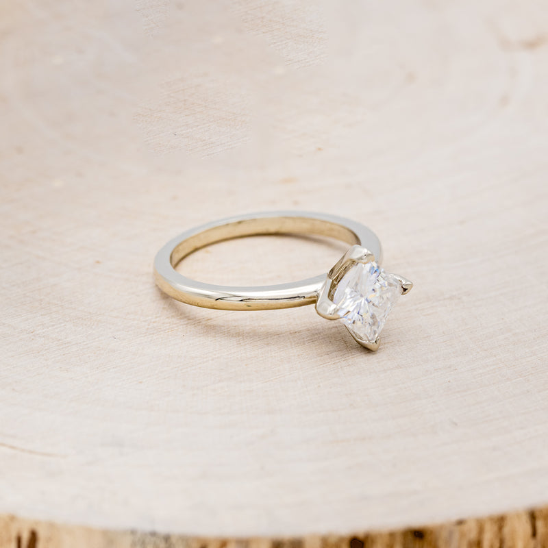 Shown here is a solitaire-style moissanite women's engagement ring, facing right. Many other center stone option are available upon request.