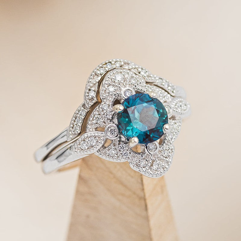 Shown here is  the "Florence" is a vintage-style round cut lab-created alexandrite women's engagement ring with diamond accents and a diamond tracer. 
