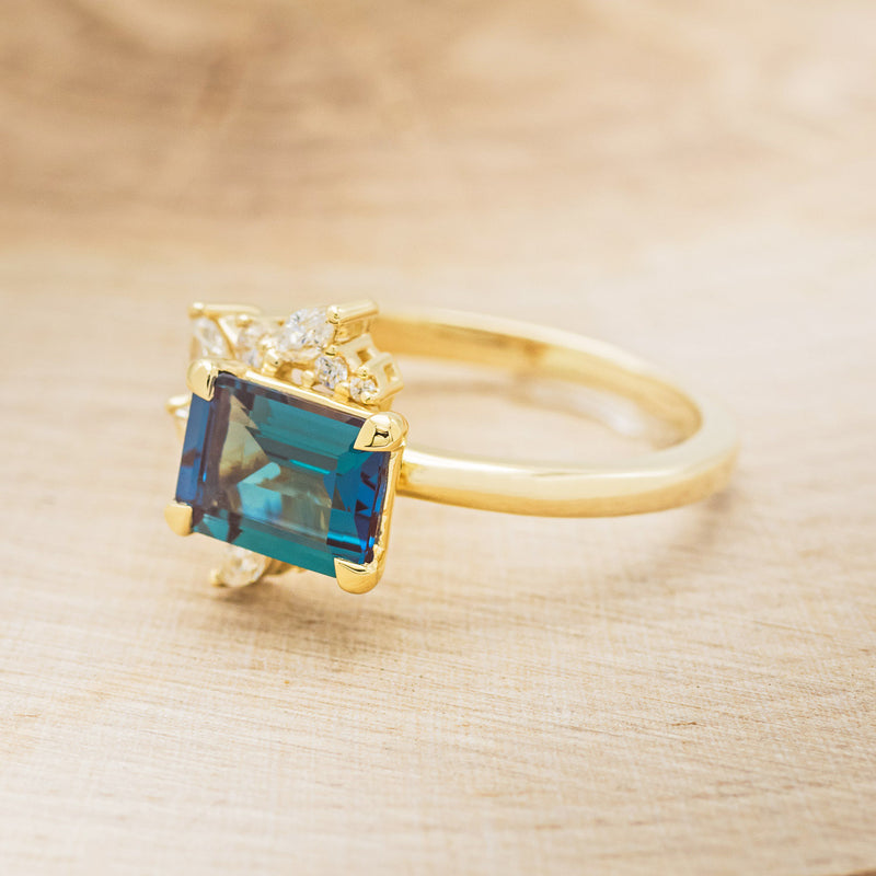 Shown here is "Aurae", an Art Deco-style lab-created alexandrite women's engagement ring with diamond accents, facing left. Many other center stone options are available upon request.