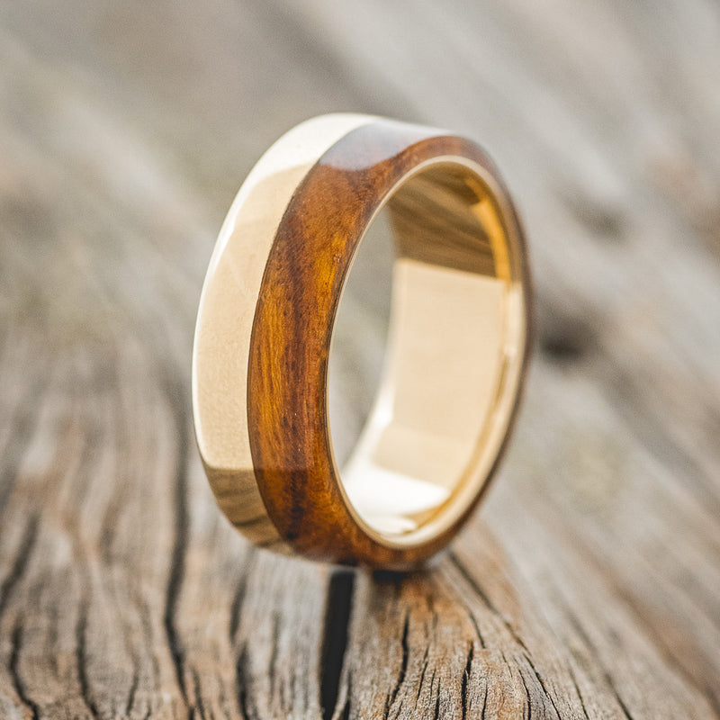 Shown here is "Ledger", a custom, handcrafted men's wedding ring featuring an ironwood overlay, upright facing left. Additional overlay options are available upon request.