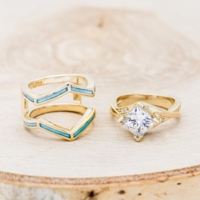 Shown here is "Lina", a moissanite women's engagement ring with diamond accents and a turquoise ring guard, laying flat together. Many other center stone options are available upon request.