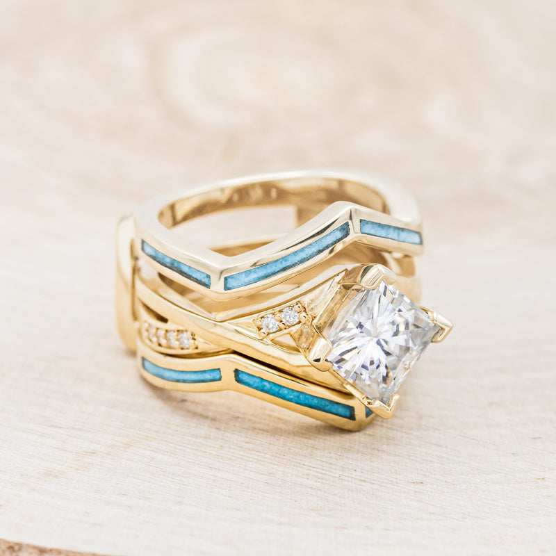 Shown here is "Lina", a moissanite women's engagement ring with diamond accents and a turquoise ring guard, facing right. Many other center stone options are available upon request.