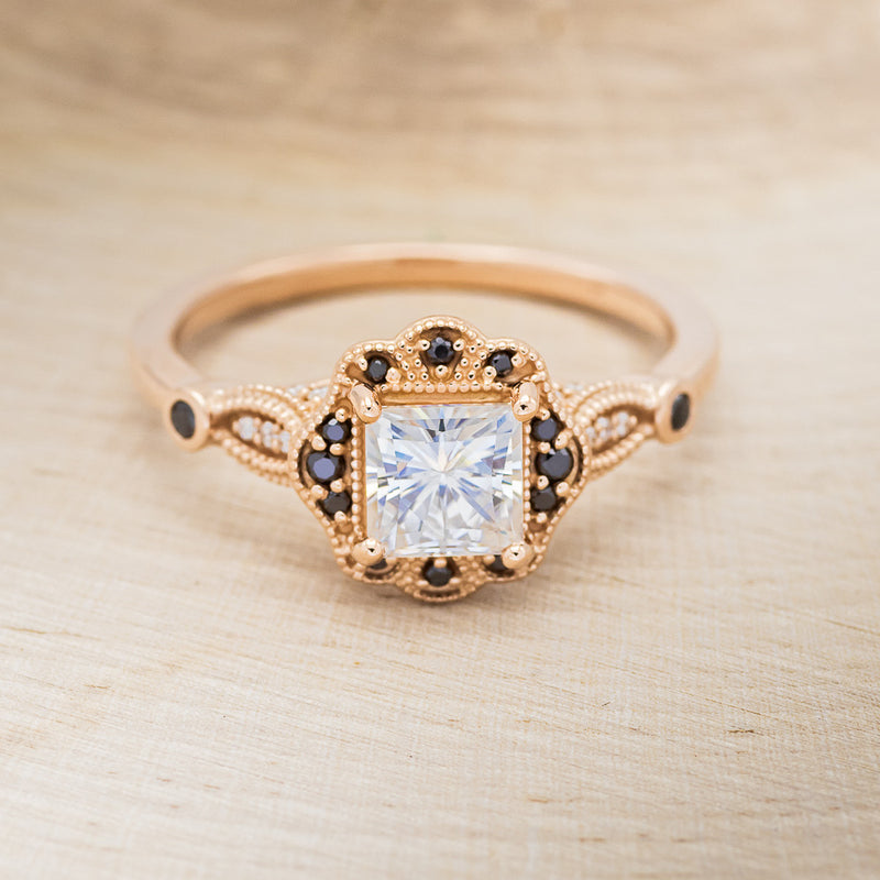 Shown here is "Eileen", a vintage-style moissanite women's engagement ring with black diamond accents, front facing. Many other center stone options are available upon request.