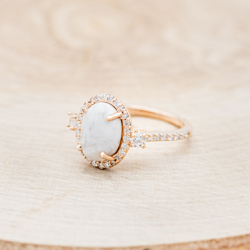 Shown here is "KB", an oval white buffalo turquoise women's engagement ring with a diamond halo and diamond accents, facing left. Many other center stone options are available upon request.