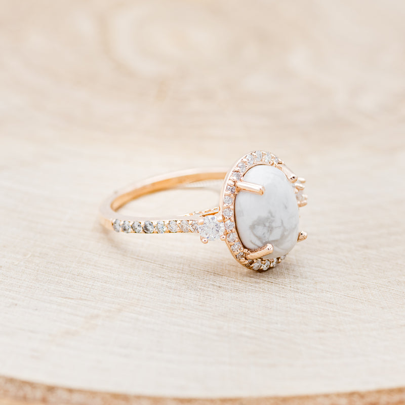 Shown here is "KB", an oval white buffalo turquoise women's engagement ring with a diamond halo and diamond accents, facing right. Many other center stone options are available upon request.