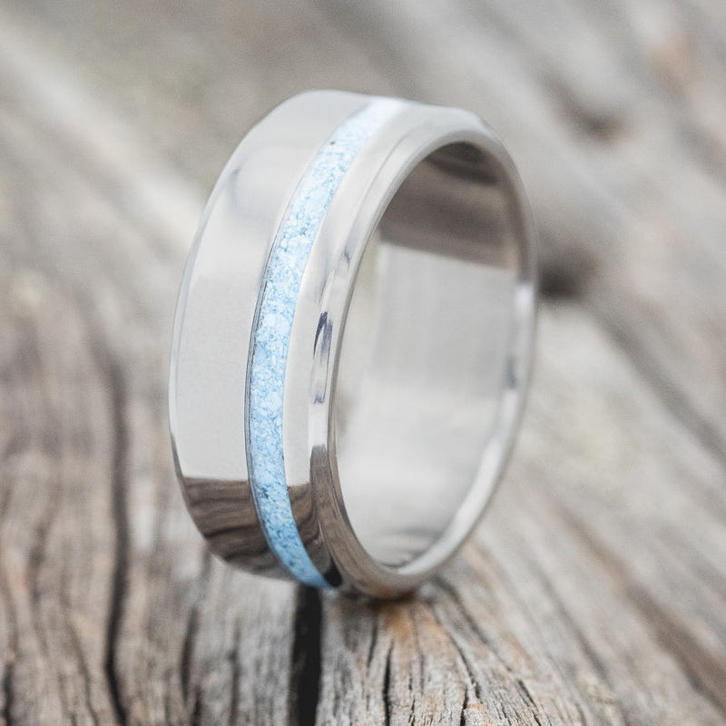 Shown here is "Vertigo", a custom, handcrafted men's wedding ring featuring a turquoise inlay, upright facing left. Additional inlay options are available upon request