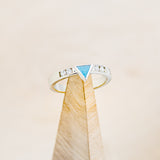 Shown here is a custom, handcrafted women's stacking band featuring a triangle channel with hand-crushed turquoise and 2 diamonds on each side of the triangle, on stand front facing. Additional inlay options are available upon request.